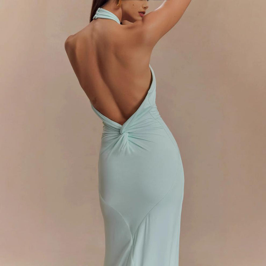 Woman wearing a light blue evening gown with a deep neckline against a beige background