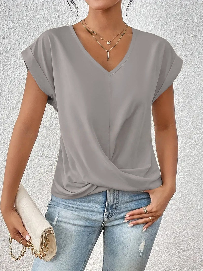 Woman wearing a gray top and blue jeans against a white background