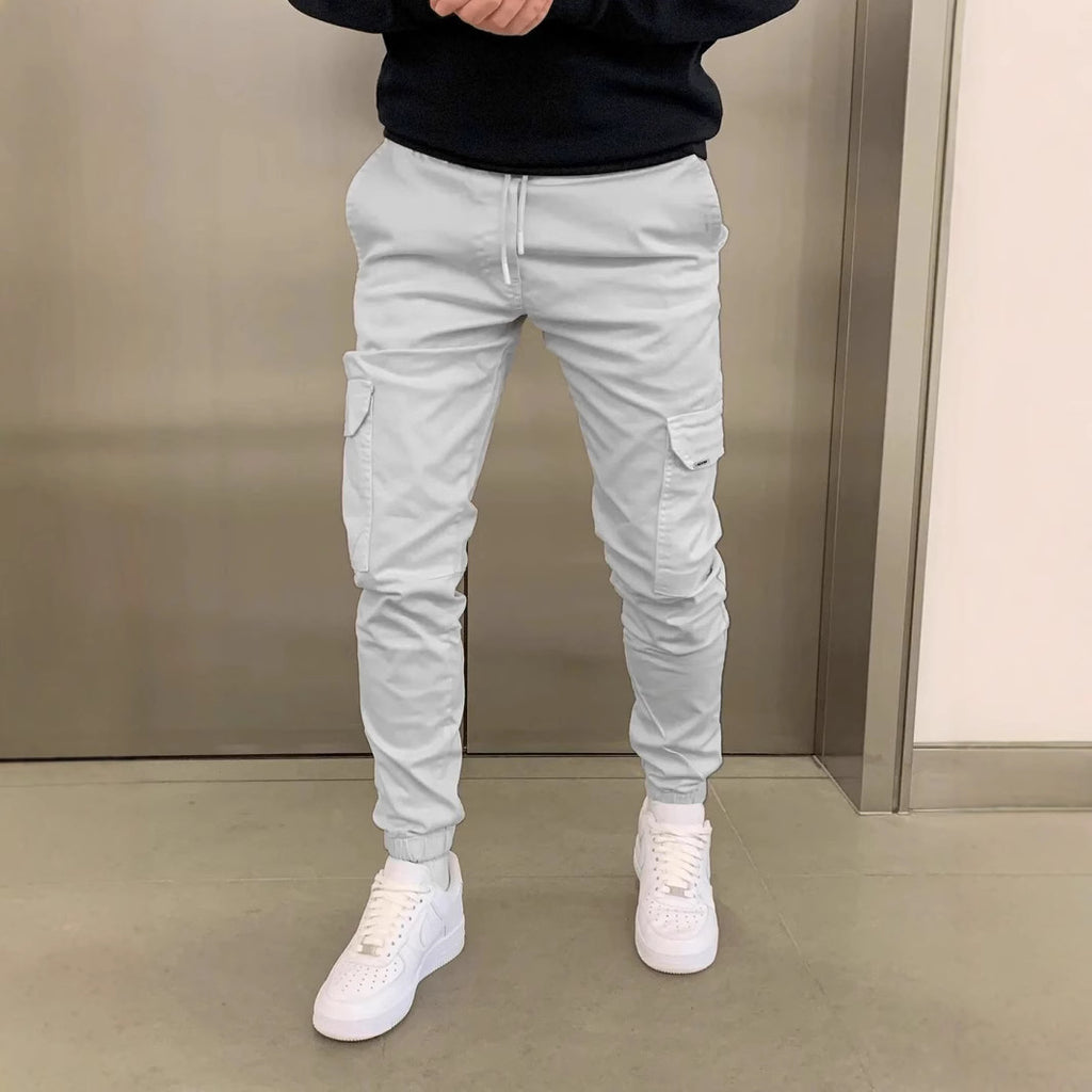 Person wearing light gray cargo jogger pants with a plain background