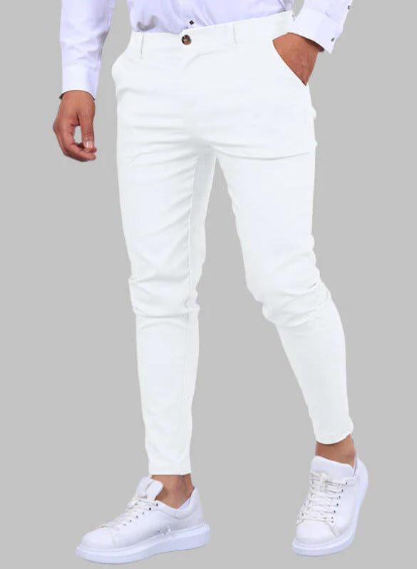 Person wearing white pants and white sneakers on a gray background