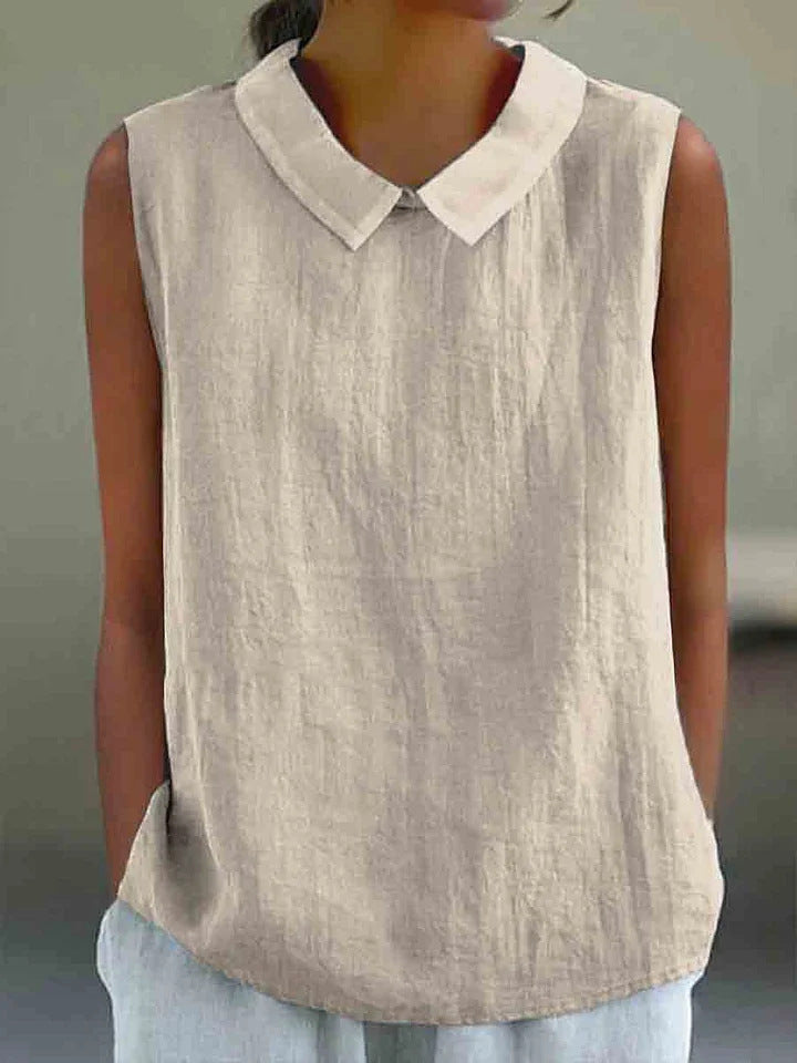 Beige sleeveless top with a white collar worn by a person against a neutral background