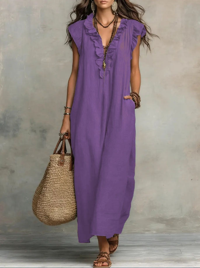 Woman wearing a purple dress holding a straw bag against a neutral background