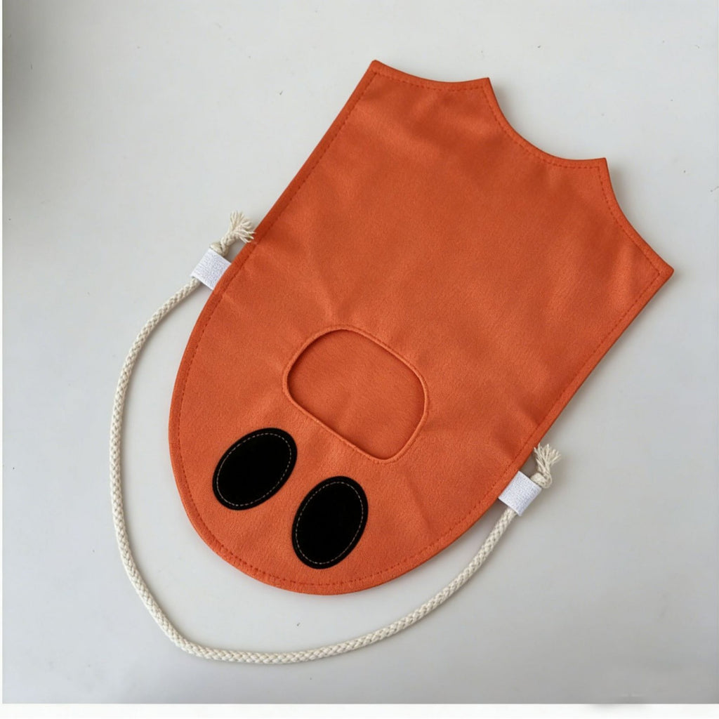 An orange dog face bib or pouch with embroidered black eyes and a cream-colored rope handle, shown on a light gray background.