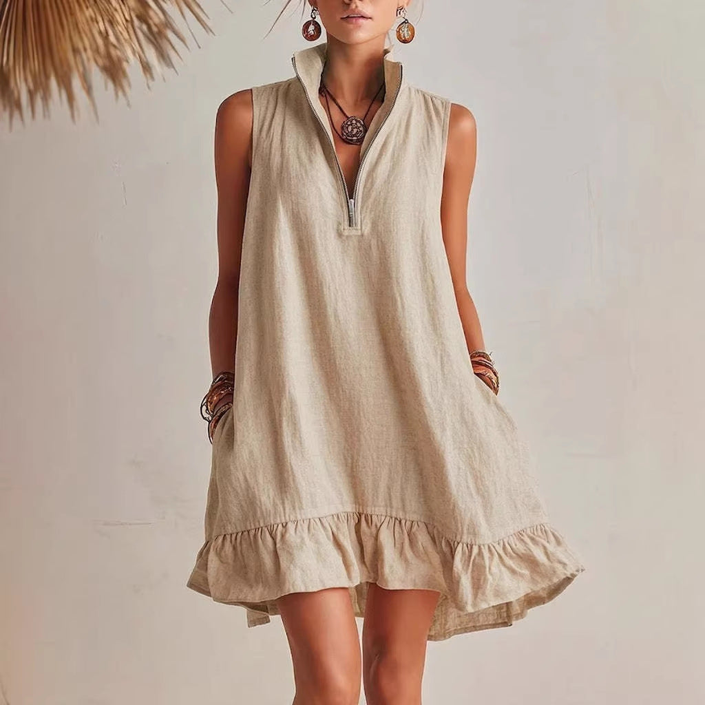 Woman wearing a beige sleeveless dress with a plain background