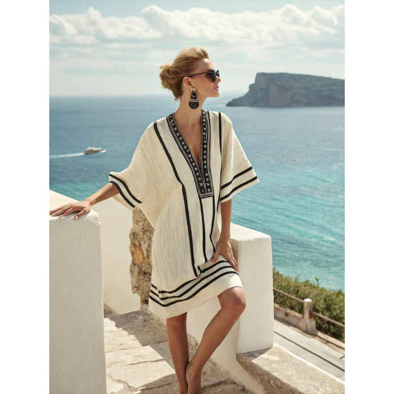Woman in a white and black dress with a scenic ocean view in the background