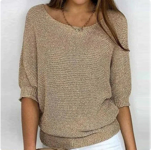 Beige knitted sweater worn by a person on a white background