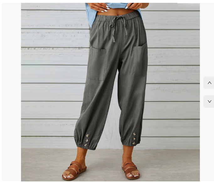 Person wearing gray cargo pants with a wooden background
