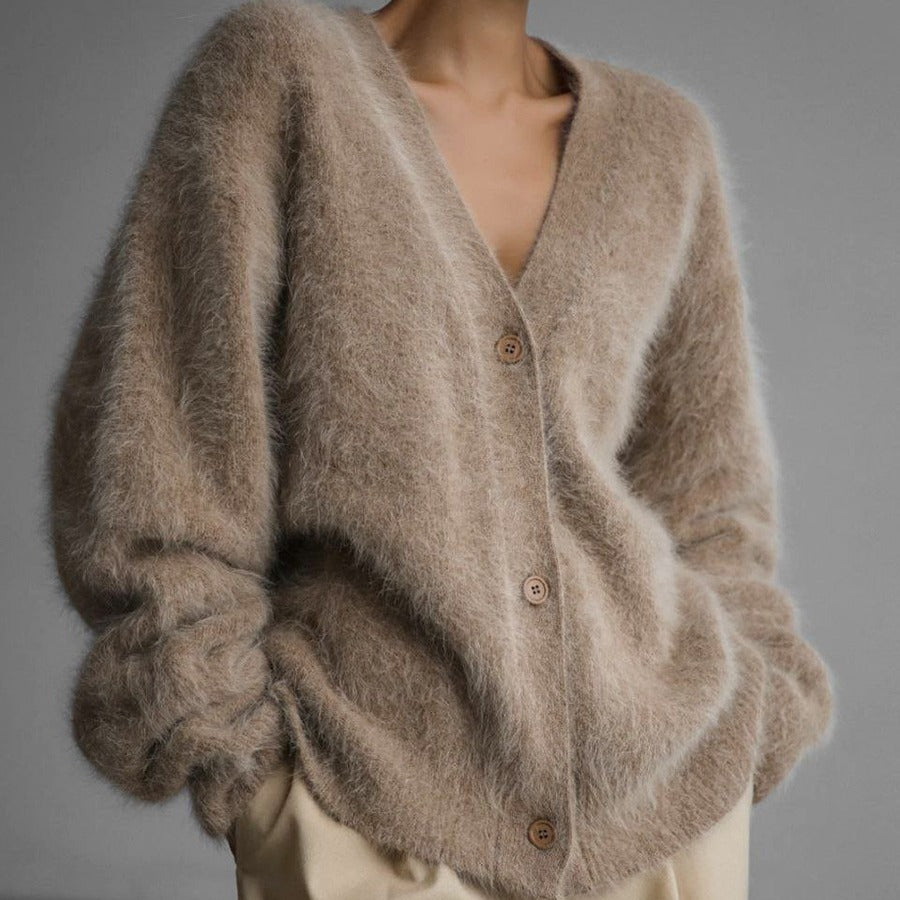 Beige cardigan worn by a person on a gray background