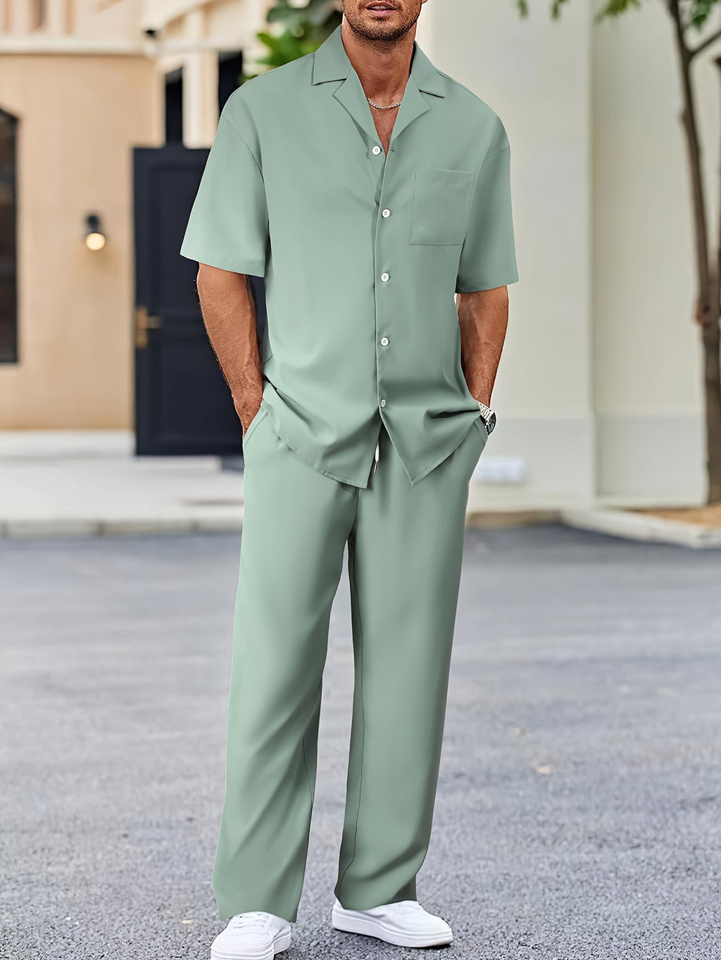 Person wearing a green outfit standing outdoors on a street.