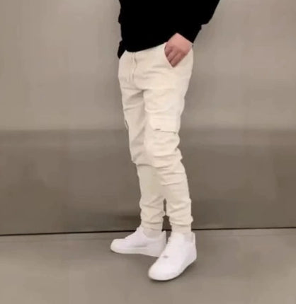 Person wearing white pants and white shoes against a plain background