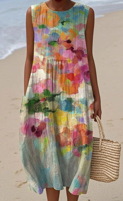 Woman wearing a colorful floral dress on a beach.