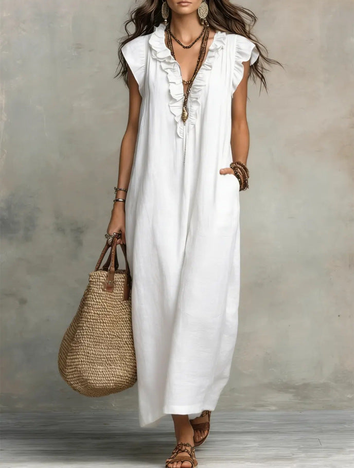 Woman wearing a white dress holding a straw bag against a neutral background