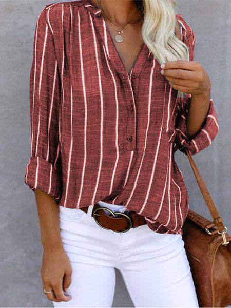 Person wearing a red and white striped shirt with white pants and a brown handbag.