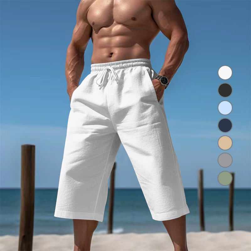 Man wearing white shorts on a beach with color swatches next to him