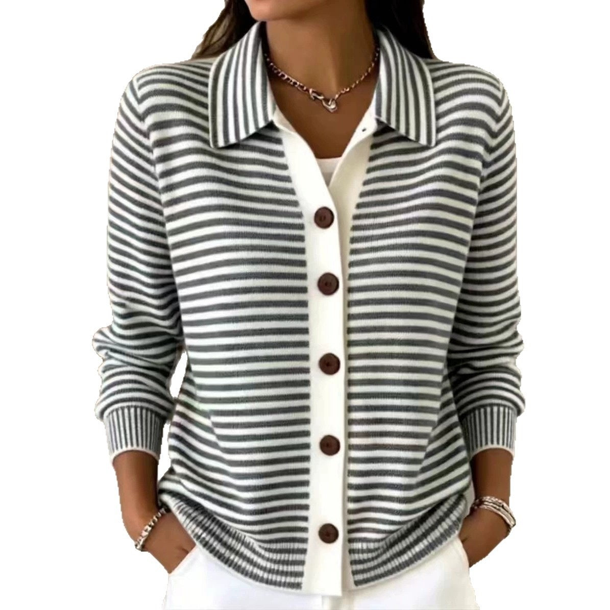 A woman wearing a gray and white horizontally striped knit cardigan with a white button placket and dark brown buttons, layered over a white top.