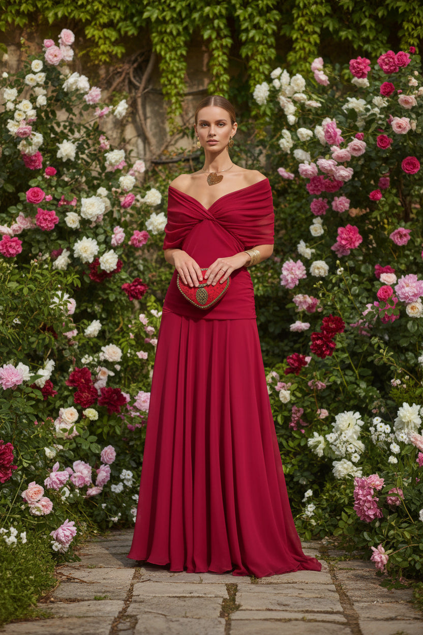 Red off-shoulder dress with a matching heart-shaped handbag background of flowers and pavement.