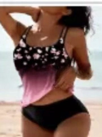 Person wearing a floral top and black shorts on a beach