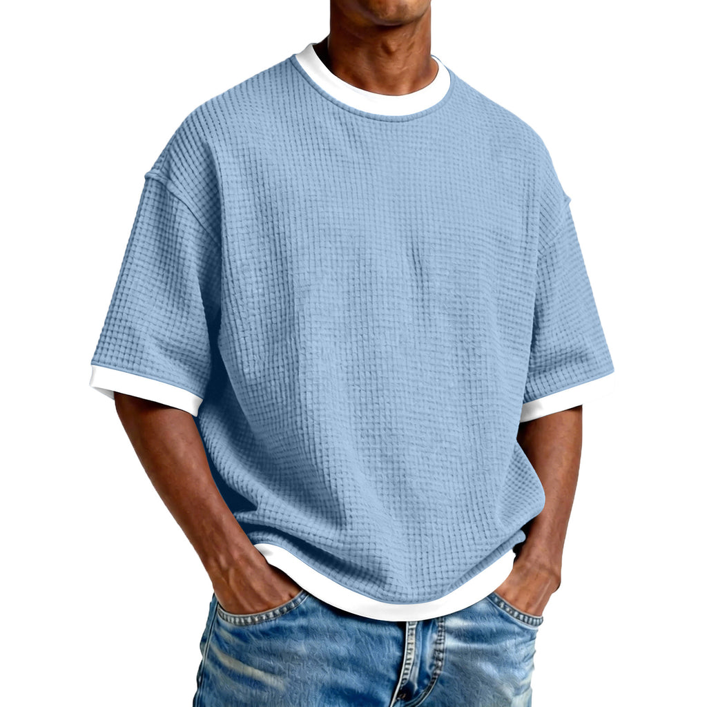 Person wearing a blue textured t-shirt with white trim on a white background