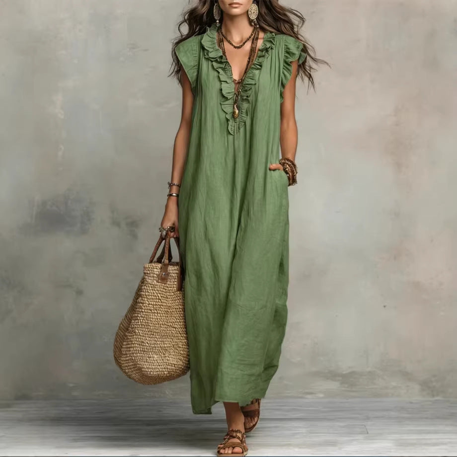 Woman wearing a green dress holding a woven bag against a neutral background