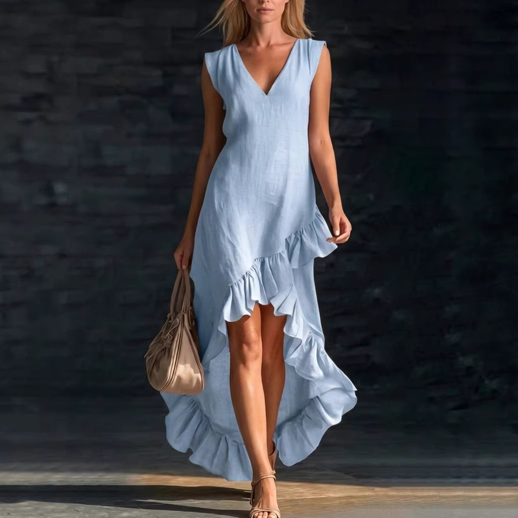 Woman wearing a light blue dress with ruffled details against a dark background