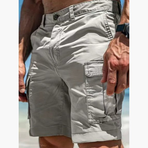 Close-up of beige shorts worn by a person on a beach.