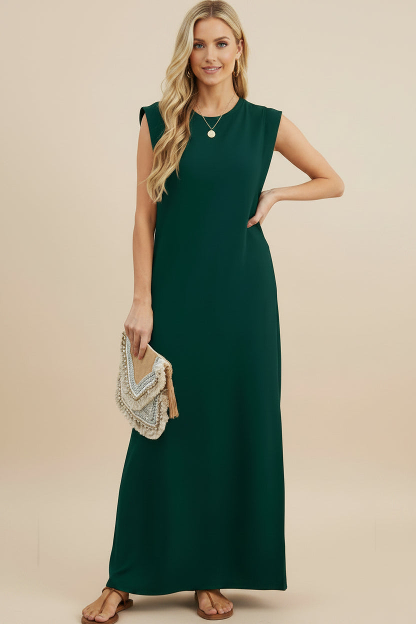 Woman wearing a green sleeveless maxi dress with a white background