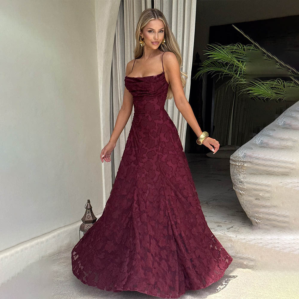 Woman in a burgundy lace dress standing indoors.