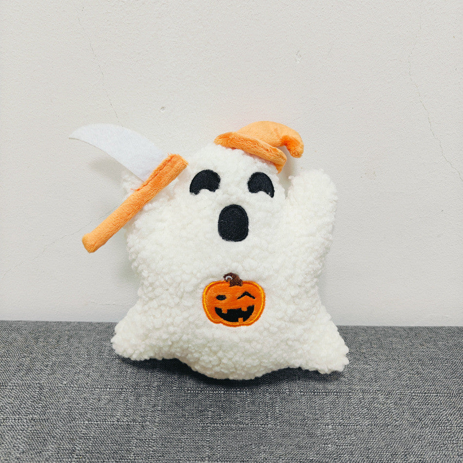 Halloween-themed plush toy with ghost and pumpkin design on a gray surface.