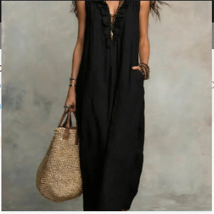 Person wearing a black dress holding a woven bag against a neutral background
