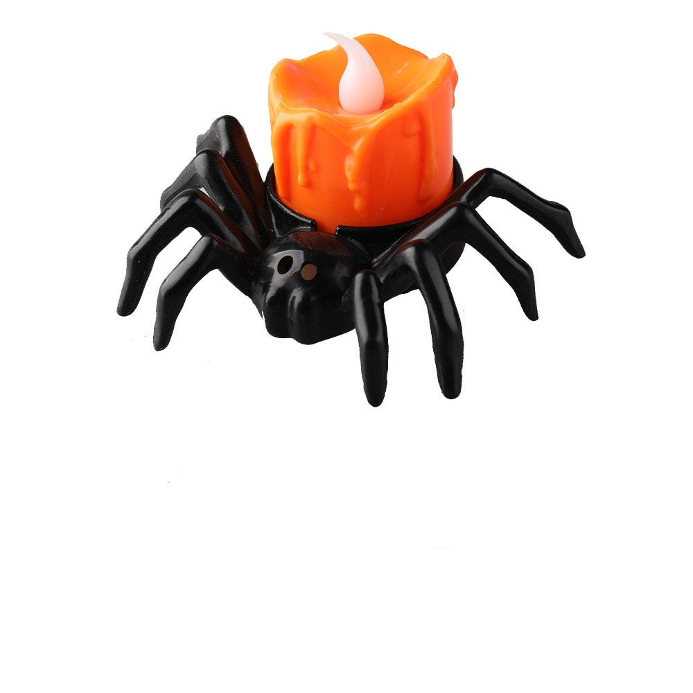 Black spider-shaped candle holder with an orange candle on a white background