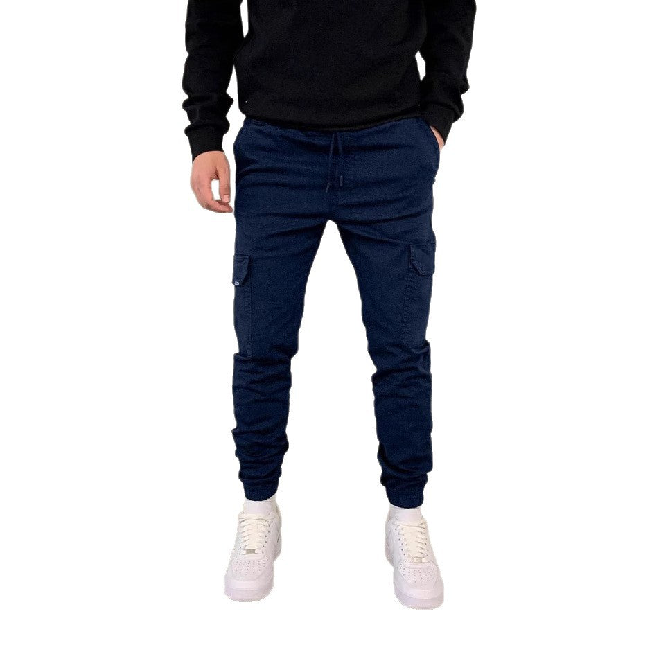 Person wearing navy cargo jogger pants with a black top on a white background