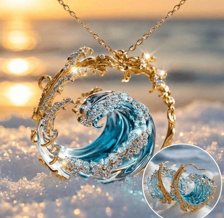 Jewelry set with blue wave pendant and gold chain against a blurred beach background