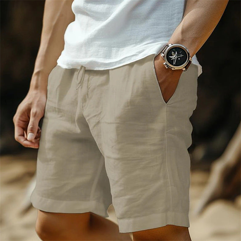 Person wearing beige shorts and a white shirt with a watch on a blurred background