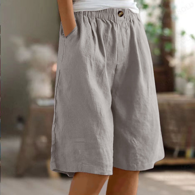 Gray shorts worn by a person with a blurred indoor background