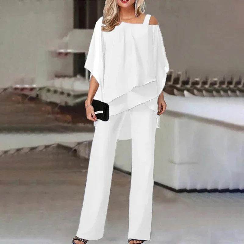 Woman in chic white off-shoulder top and pants set, holding black clutch, ZA-Zola fashion