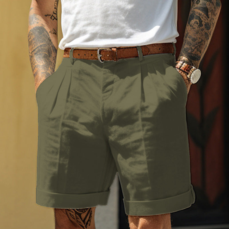 Person wearing green shorts with a white shirt and brown belt.