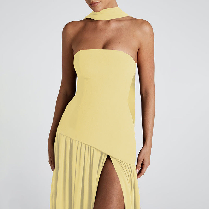 Yellow strapless dress with a high slit on a plain background
