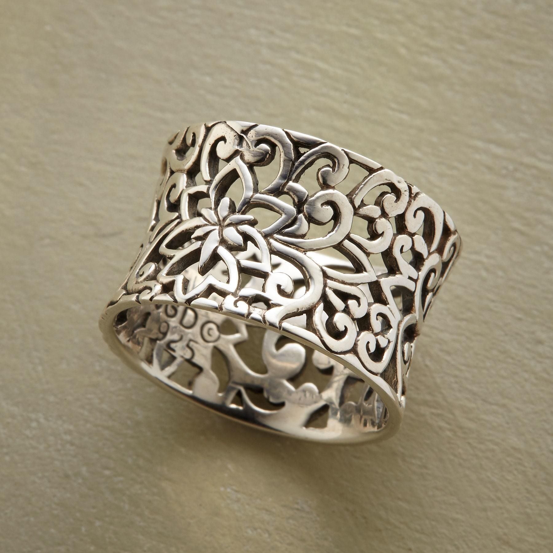 Silver filigree ring on a beige background