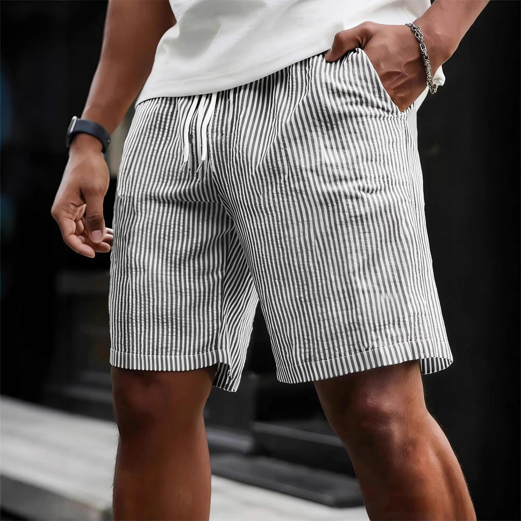 Person wearing black and white striped shorts with a blurred background