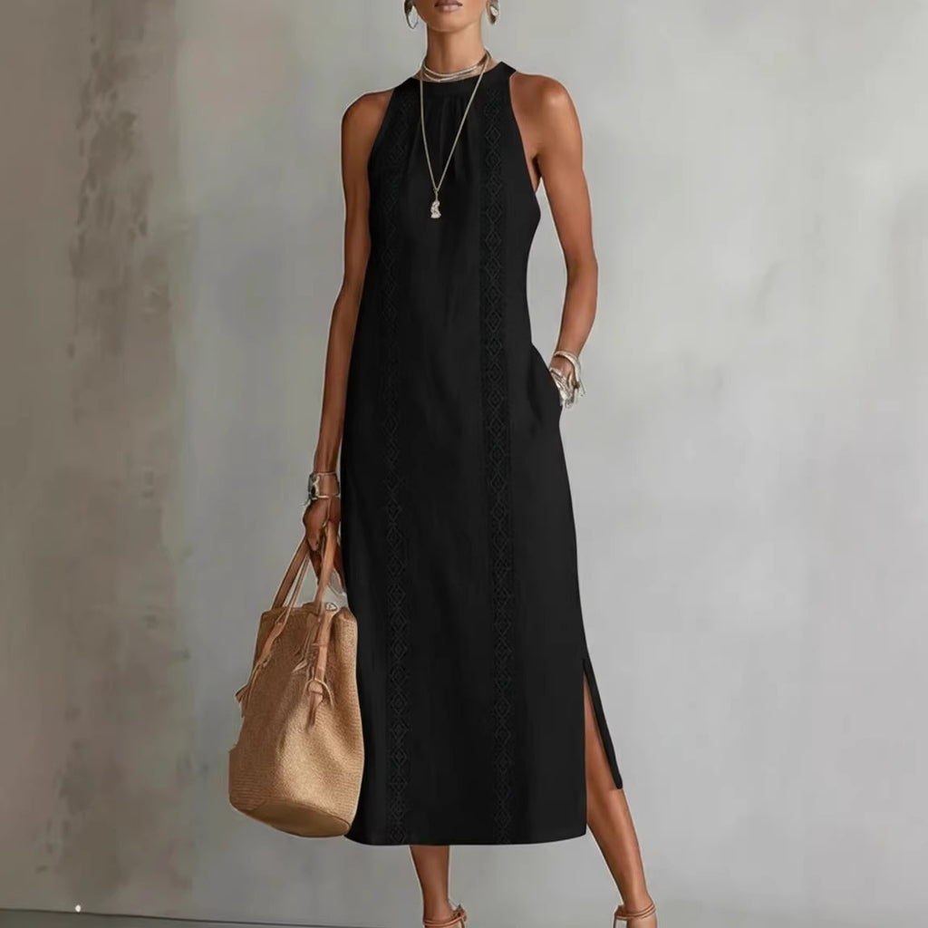 Woman wearing a black sleeveless dress holding a beige handbag against a neutral background