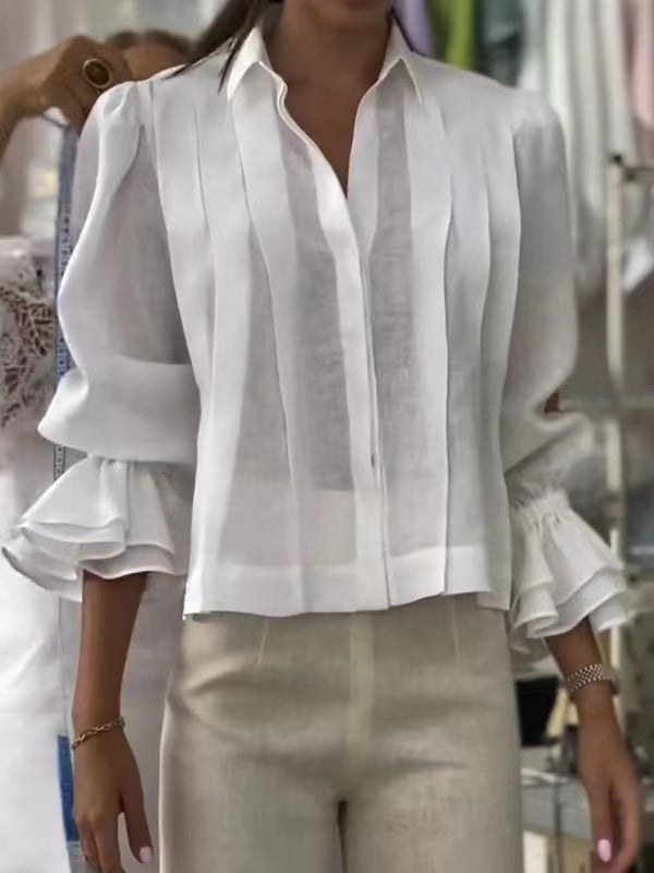 White blouse with ruffled sleeves worn by a person, blurred background