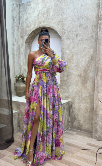 Woman taking a mirror selfie wearing a colorful floral dress in an indoor setting.