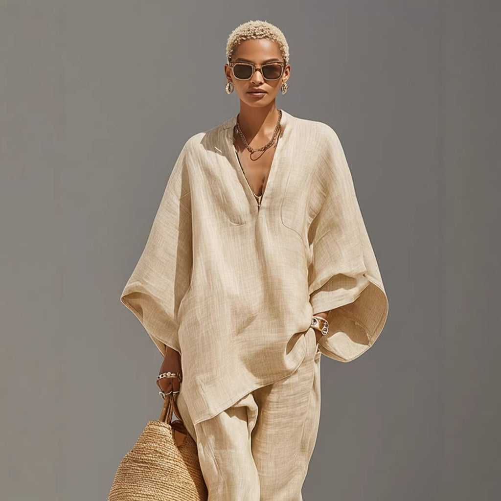 Woman wearing a beige outfit with sunglasses against a gray background
