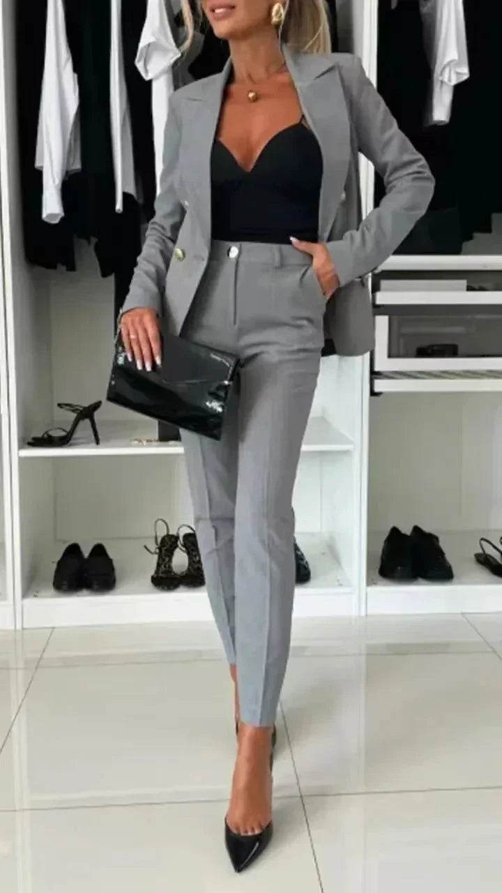Woman in chic grey suit with black top, heels, and clutch, ZA-Zola trendy office fashion.