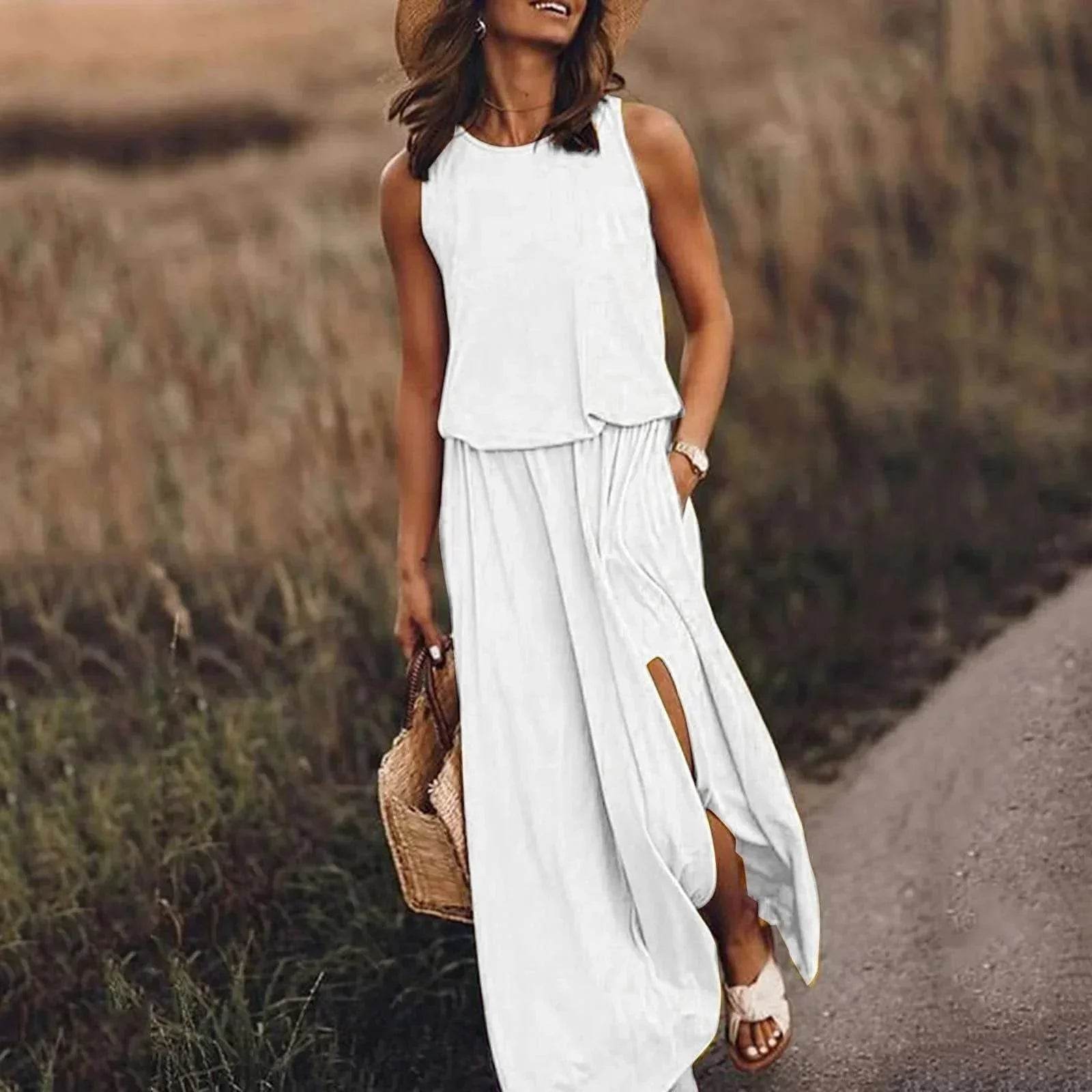 Woman in a stylish white maxi dress, straw hat, and sandals walking on a rural path, carrying a woven bag, ZA-Zola trendy fashion UK