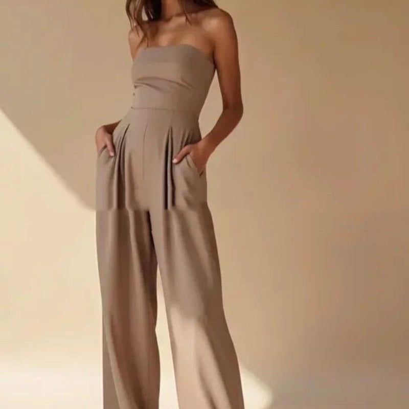 Woman wearing a beige strapless jumpsuit against a beige background
