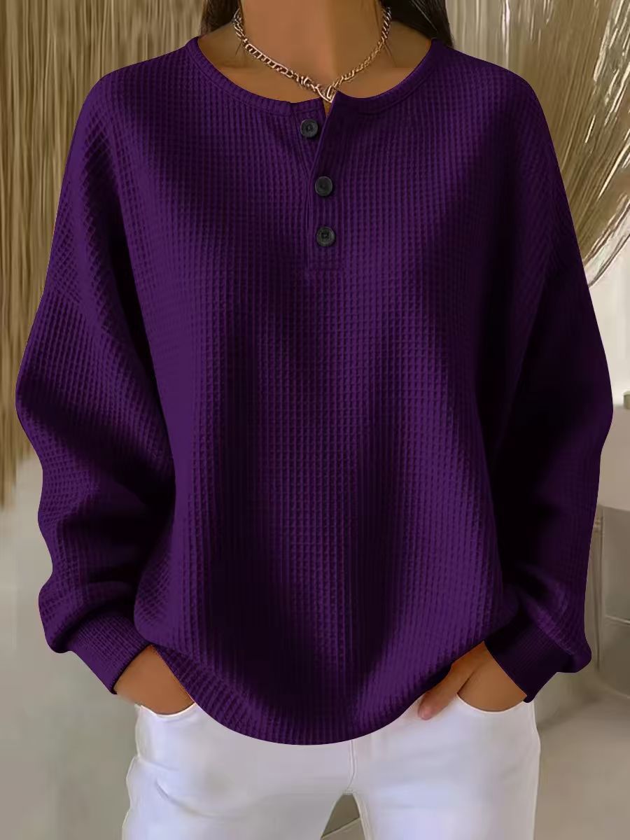 Purple textured shirt worn by a person with white pants against a neutral background