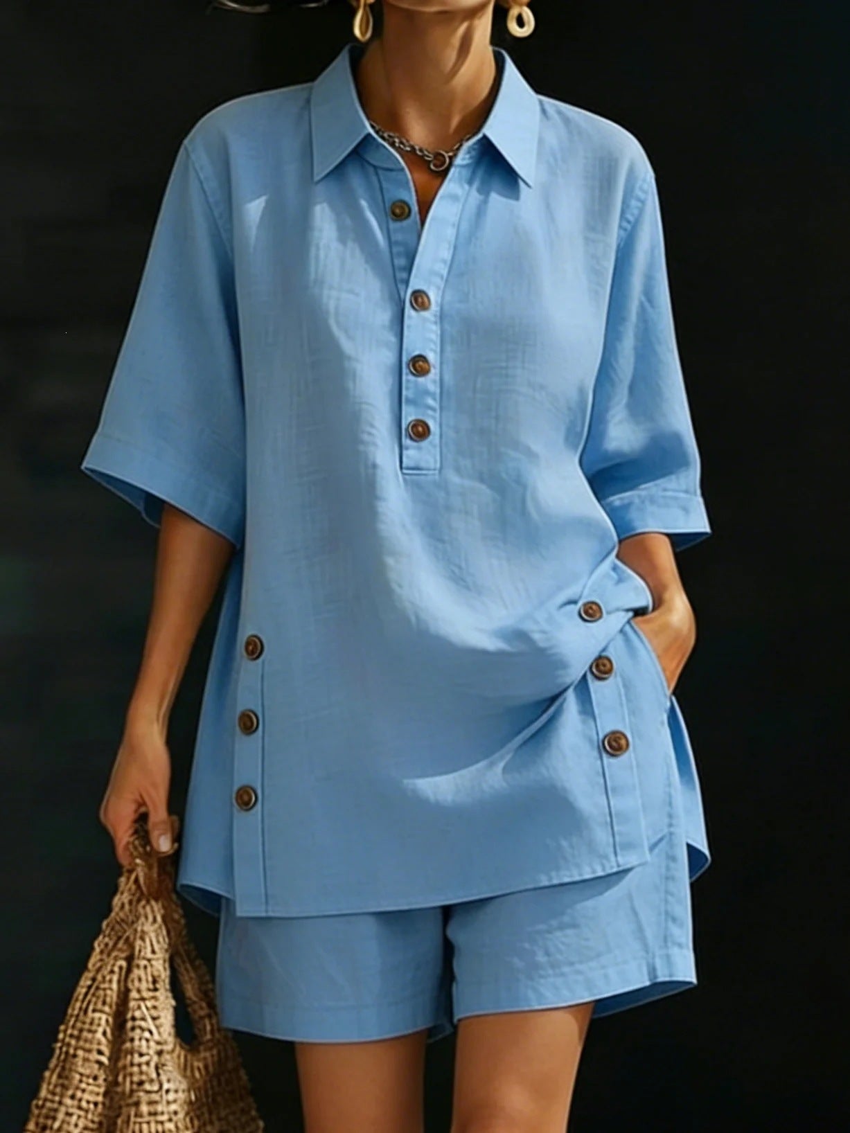 Person wearing a blue outfit with buttons against a dark background