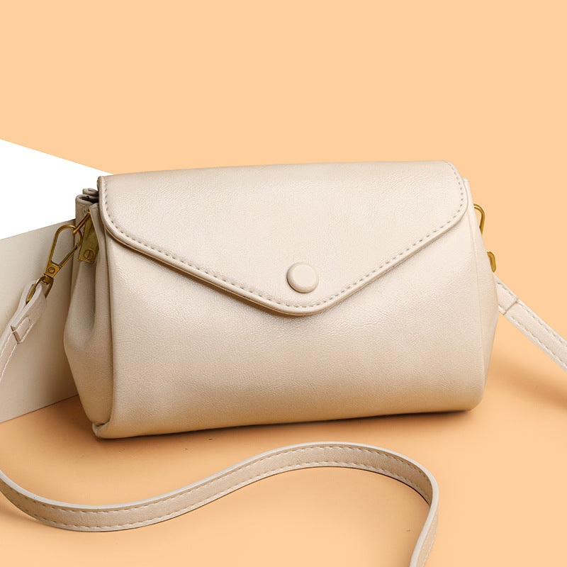 Beige handbag with a strap on a beige background