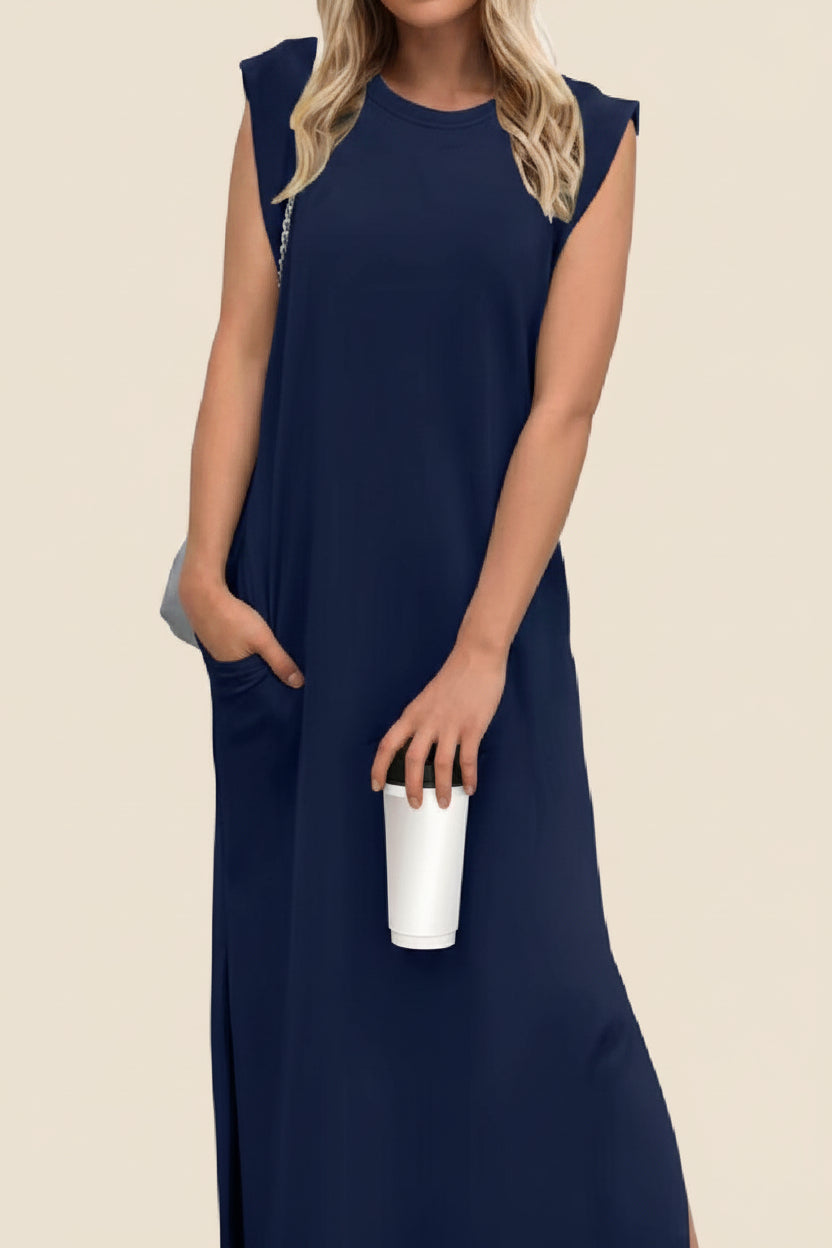 Woman wearing a navy blue sleeveless dress holding a white clutch on a white background